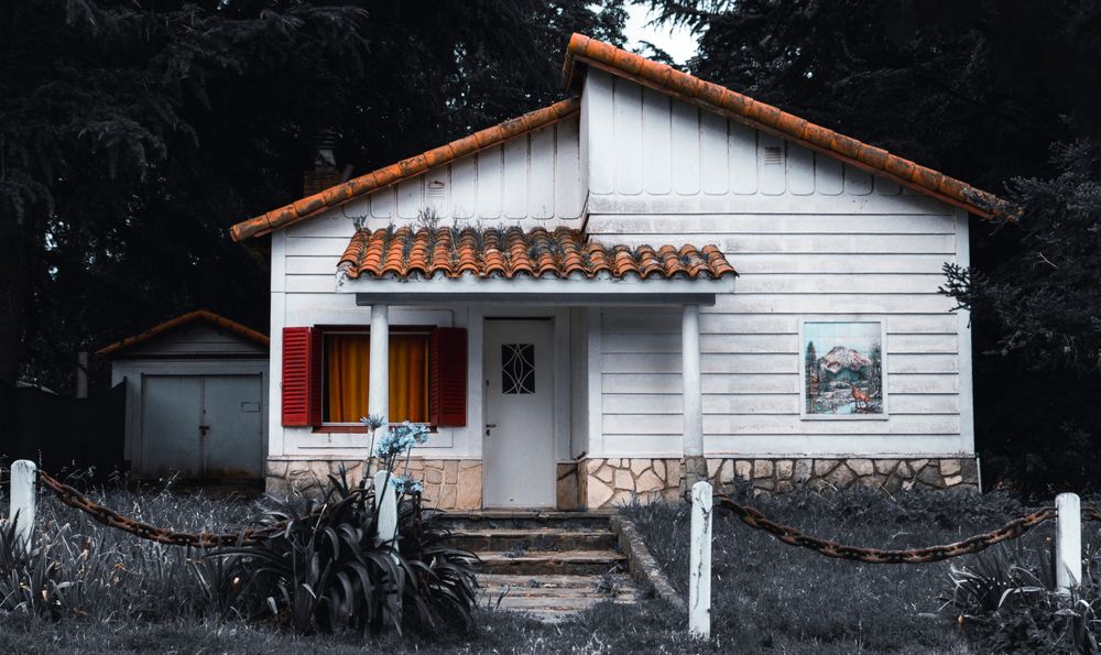 White bungalow with a red-tiled porch roof