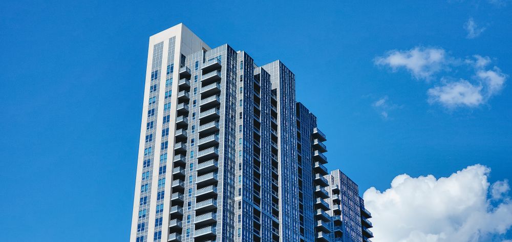 Stock photo: glass condo tower against a blue sky
